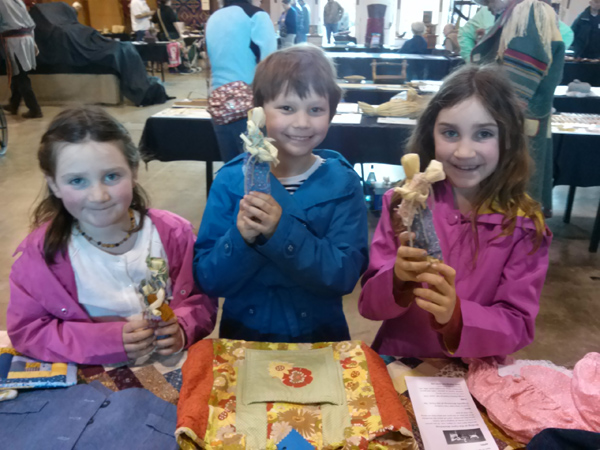 girls show their corn dolls at heritage fair