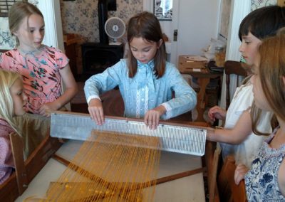 girls working the pioneer loom homeschool