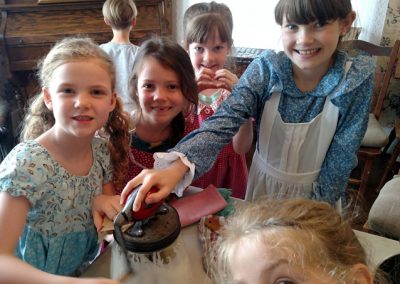 kids churning butter homeschool pioneers homesteading