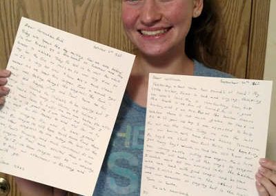 teen with letters from the Oregon Trail presentation singing creek center history