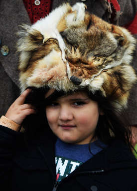 child wearing animal fur hat at living history festival