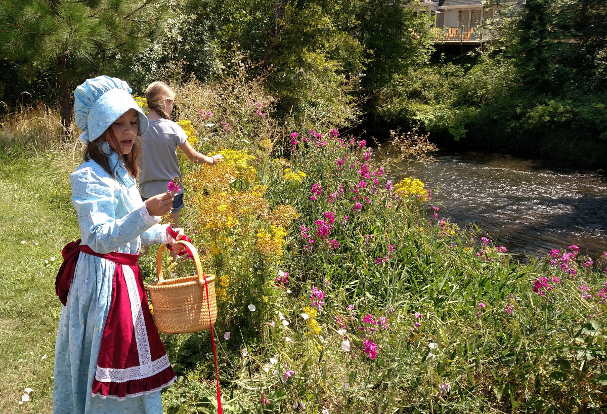 girls picking flowers by river