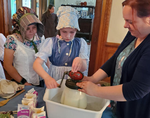 kids churn butter at the smj house in Eugene with Singing Creek Educational CEnter