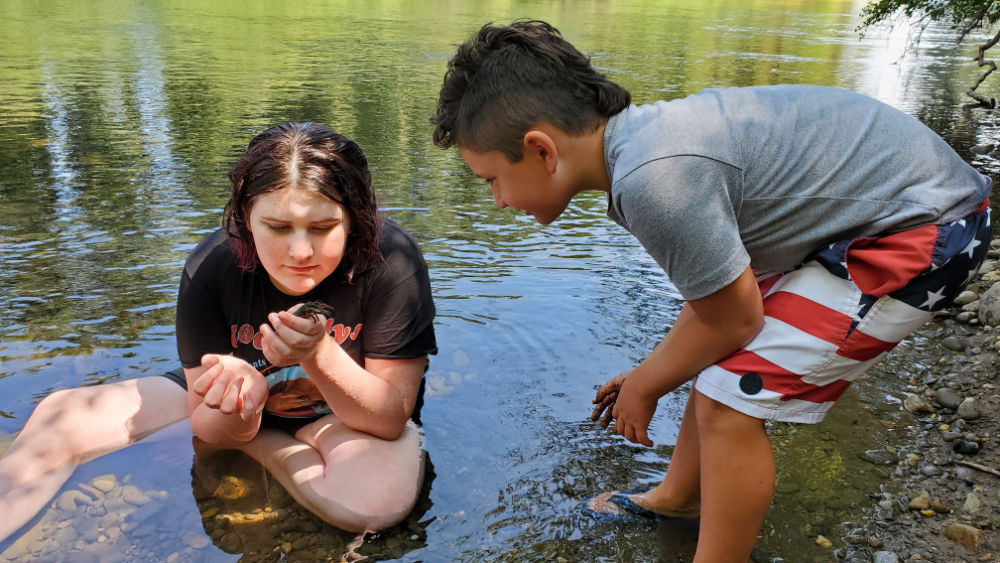 kids in river for summer camp teaching