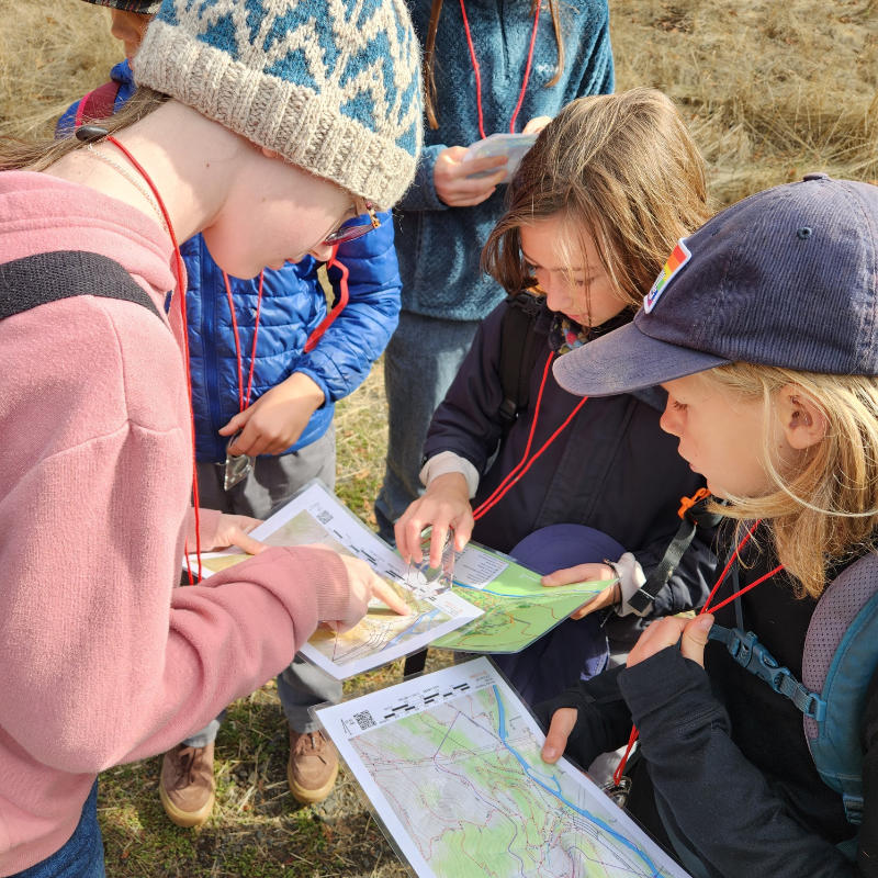 kids working on map and compass-close up