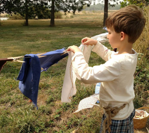 boy hanging laundry at summer camp