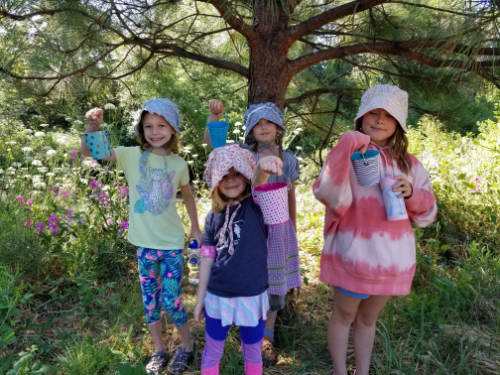 girls in nature with buckets summer camp 