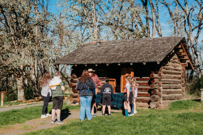Joe with kids at the pioneer cabin field trip
