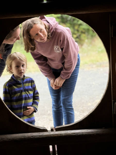 people looking in the door of the plankhouse