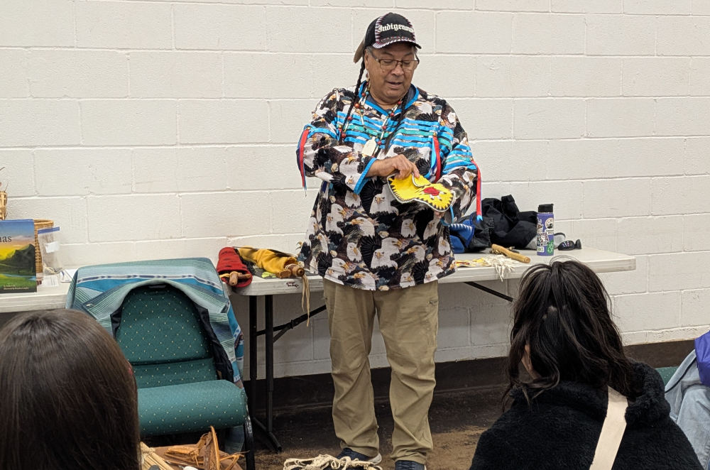Deitz showing beaded moccasins to students